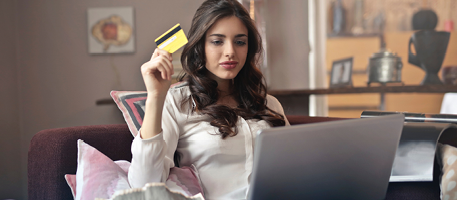 Young woman holding credit card on laptop