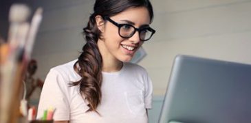 woman looking at computer smiling and interested