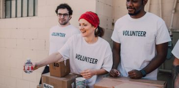 nonprofit volunteers for a cause, one is giving a small bottle of water away